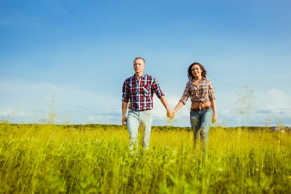 Couple marchant à travers le champ — Photo