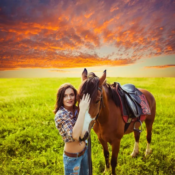 Beautiful woman standing near a horse — Stock Photo, Image