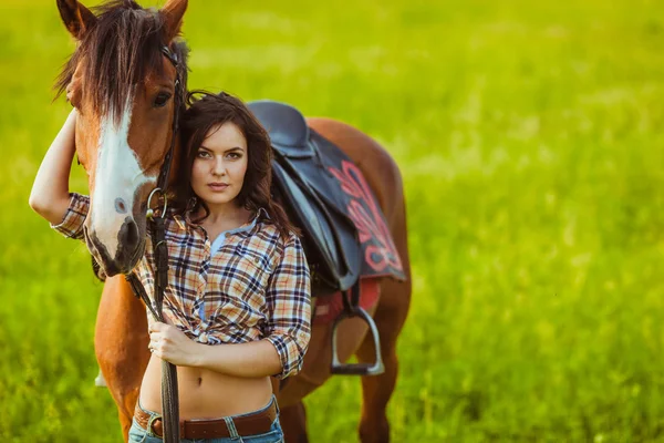 Hermosa mujer de pie cerca de un caballo — Foto de Stock