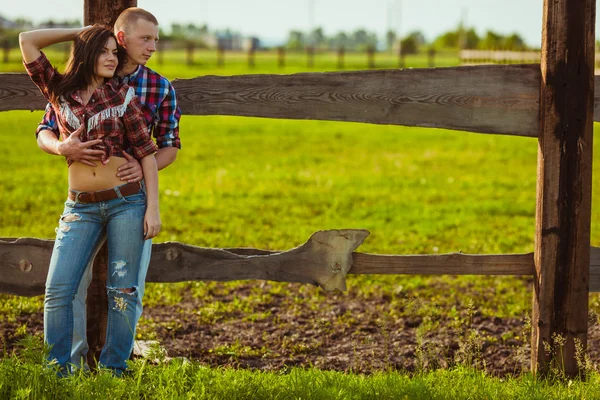 Casal na fazenda olhando perto da cerca — Fotografia de Stock