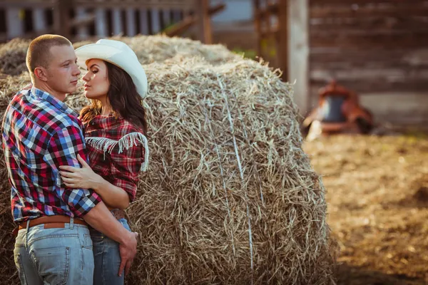 Pareja abrazando cerca de heno — Foto de Stock