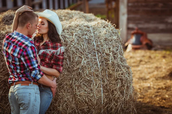 Pareja abrazando cerca de heno —  Fotos de Stock