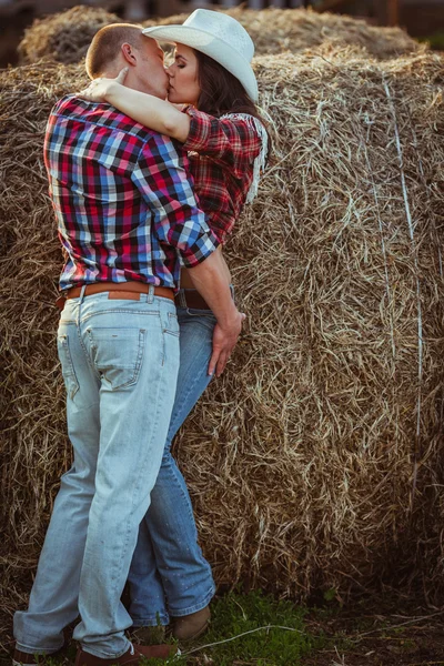 Casal beijando perto de feno — Fotografia de Stock