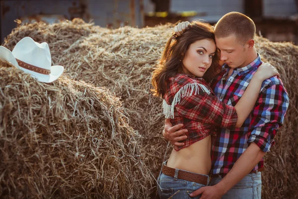 Pareja abrazando cerca de heno — Foto de Stock