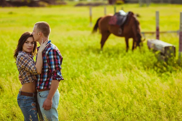 Couple debout à la ferme avec des chevaux — Photo