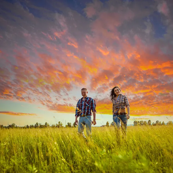 Paar wandelen door het veld — Stockfoto