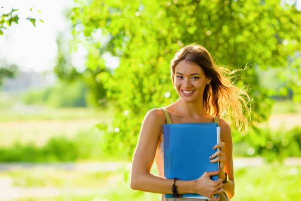 Student tjej stående håller blå mapp — Stockfoto
