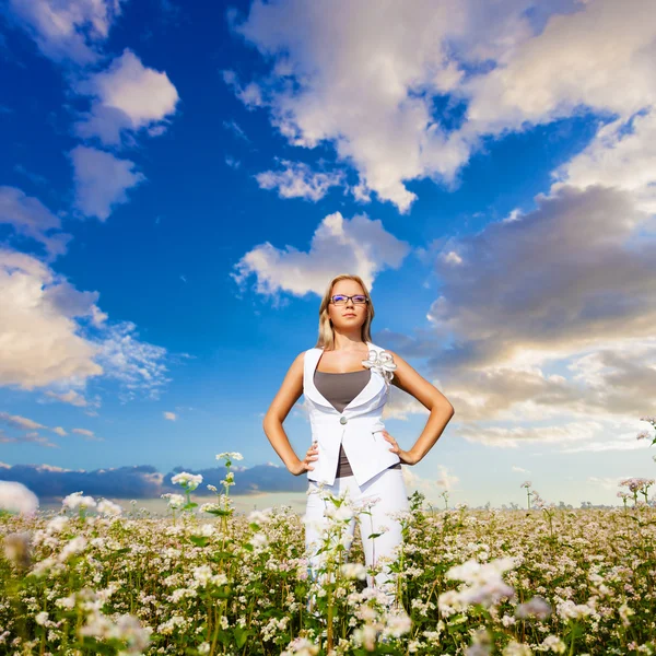 Businesswoman standing on flowers field — Stock Photo, Image