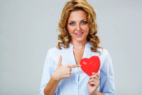 Sério mulher segurando símbolo coração vermelho — Fotografia de Stock
