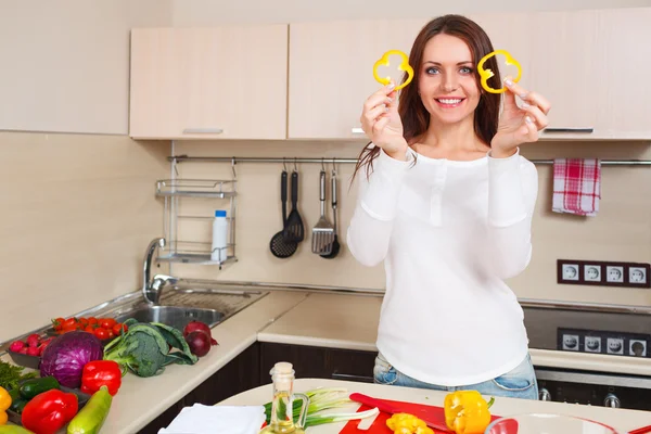 Улыбающаяся молодая домохозяйка смешивает свежий салат — стоковое фото
