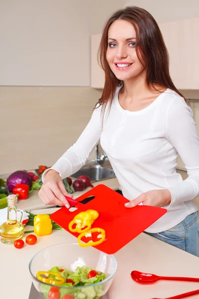 Souriante jeune femme au foyer mélangeant salade fraîche — Photo