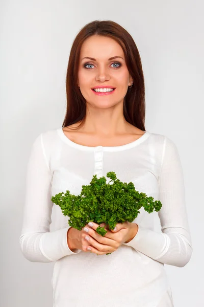 Schönes Mädchen mit zwei Bündeln Petersilie in der Nähe des Gesichts — Stockfoto