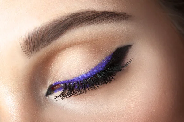 Detailní záběr oka s make-up - šipka černá a fialová — Stock fotografie