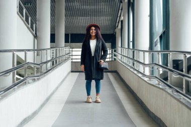 Dönüşümde genç bir kadın ortada duruyor ve gülümsüyor.