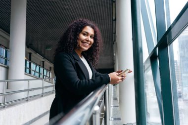 Geçiş bölgesindeki genç kadın kameraya bakıyor.