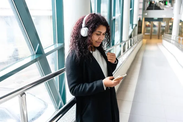 Mulher Jovem Zona Transição Usando Fones Ouvido Olhando Para Smartphone — Fotografia de Stock