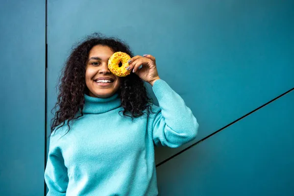 Jonge Lachende Vrouw Met Gele Donut Buurt Van Muur Stockafbeelding