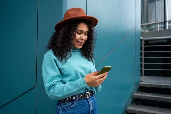 Mujer Joven Mirando Teléfono Inteligente Pie Cerca Pared Color Aqua Imagen de stock