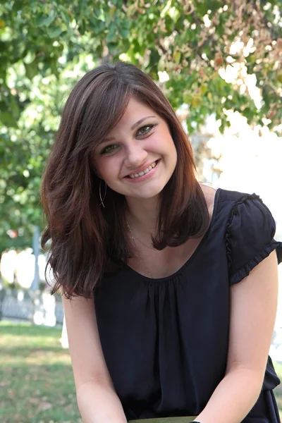 Portrait of a young beautiful smiling girl in a park — Stock Photo, Image