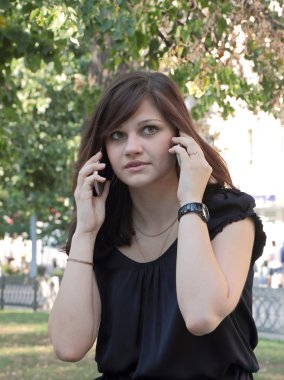 Kız iki cep telefonlarında konuşma