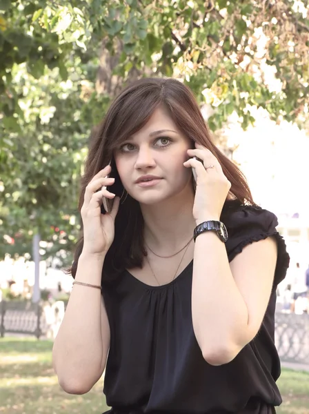 Meisje spreken over twee mobiele telefoons — Stockfoto
