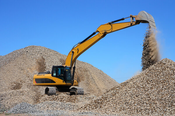 Дредж загружает щебень
