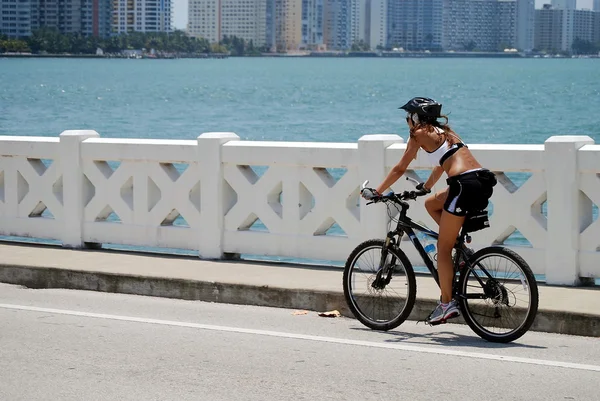 Mujer joven montando una bicicleta — Foto de Stock