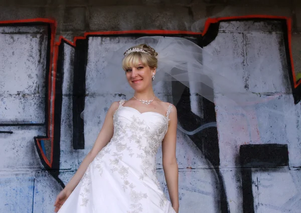 Bride wait for her groom on graffiti wall background — Stock Photo, Image