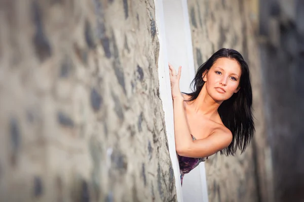 Bella ragazza bruna posa vicino parete rocciosa — Foto Stock