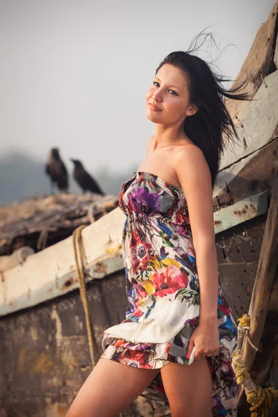 Jovem morena posando perto de barco — Fotografia de Stock