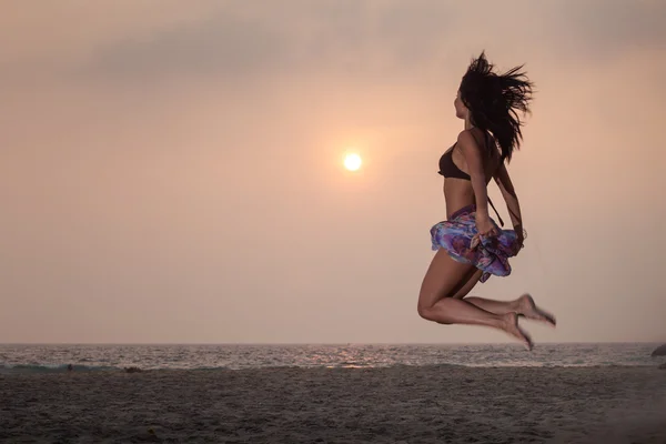 Brunette girl in flower skirt jumping — Stock Photo, Image