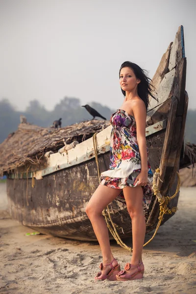 Jovem morena posando perto de barco — Fotografia de Stock