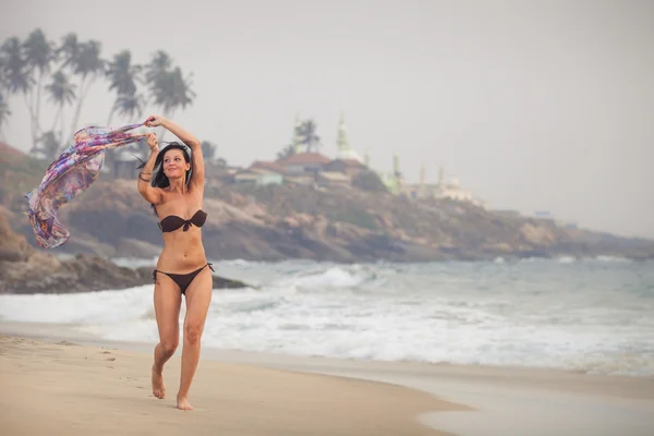 Morena chica ejecutar en la playa — Foto de Stock