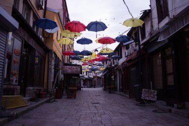 Üsküp, Kuzey Makedonya - 4 Mayıs 2021. Üsküp 'ün Eski Kasabası' nda renkli şemsiyeler asılı. Sabah ıssız bir sokakta.