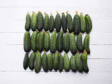 Olgunlaşmış salatalıklar, beyaz ahşap arka plan. Yeşil sağlıklı sebzeler.