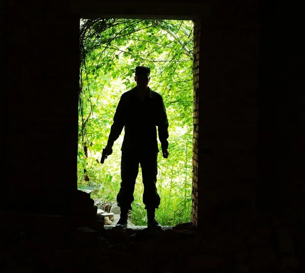 Soldato con una pistola di fronte alla porta Fotografia Stock