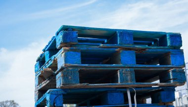 Blue wooden pallets outside isolated with blue sky