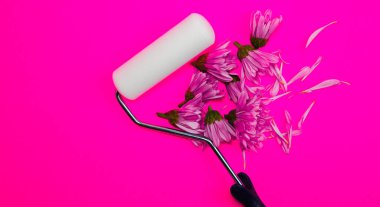 Pembe arka planda pembe çiçekli boya silindiri yakın plan