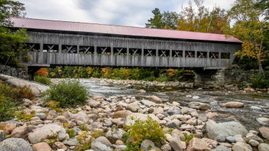 BEYAZ DAĞLARI, NEW HAMPSHIRE, ABD - 2 Ekim 2022: Beyaz Dağ Ulusal Ormanı 'nda Kancamagus karayolu yakınındaki kapaklı köprü 1858 yılında Albany kasabası tarafından yenilendi.