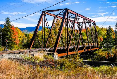 Sonbahar renkleriyle demiryolu demir köprüsü güneşli bir günde mavi gökyüzü