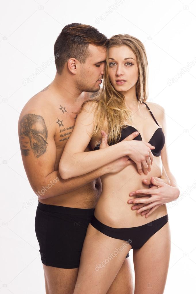 Sexy young passionate couple hugging on white isolated background