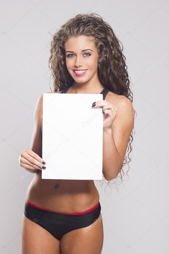 Beautiful fitness woman holding white blank sign