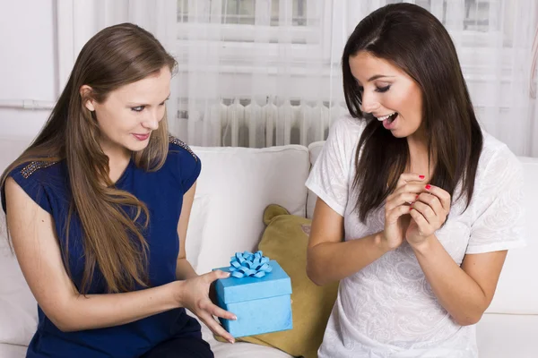 Two beautiful girlfriends giving present to each other — Stock Photo, Image