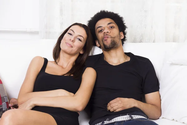 Munter interracial par hjemme - Stock-foto