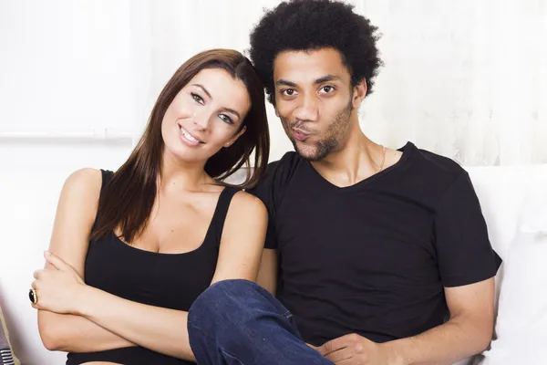 Munter interracial par hjemme - Stock-foto