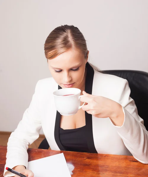 Junge ernsthafte Geschäftsfrau im Büro an ihrem Schreibtisch — Stockfoto