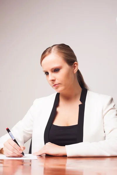 Junge ernsthafte Geschäftsfrau im Büro an ihrem Schreibtisch — Stockfoto