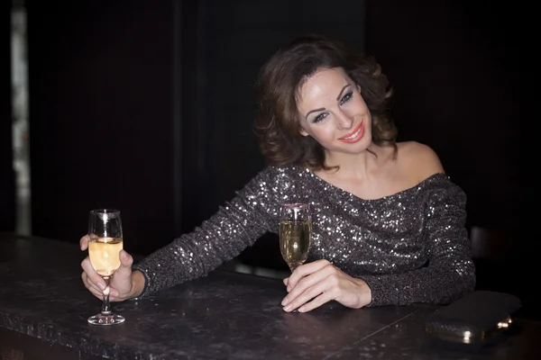 Beautiful elegant woman drinking champgane in the club — Stock Photo, Image