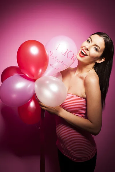 Smuk kvinde med Valentinsdag dekorationer på lyserød baggrund - Stock-foto