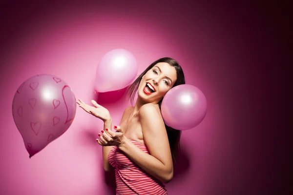 Beautiful woman with valentines day decorations on pink background — Stock Photo, Image